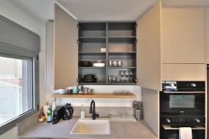 una cucina con un lavello e un piano di lavoro di Luxe on the BEACH By LIME a Haifa Altre 77 foto