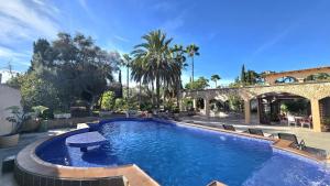 a large swimming pool in a yard with a building at Castell Villa Bohío Mallorca in Urbanicacion ses palmeres
