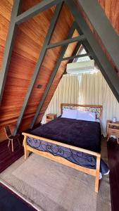 a bedroom with a large bed in an attic at Cabana Catuaí in Espera Feliz