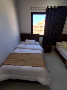 a bedroom with two beds and a window at Luxury units for rent on the sea in Marsa Matruh +5 photos