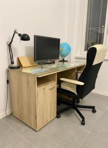 un bureau avec un écran d'ordinateur et une chaise dans l'établissement CASTE Apartment, 1-4 guests, Garage, Historical Downtown, à Vinohrady