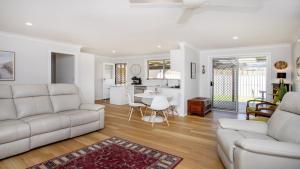 a living room with a couch and a table at Oceanique in Old Bar +16 photos