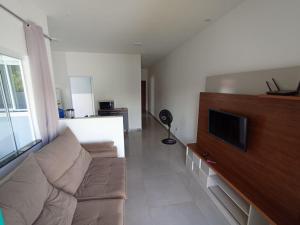 a living room with a couch and a flat screen tv at Casa Rua da Lagoa in Araruama
