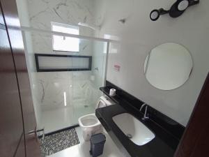 a bathroom with a glass shower and a toilet at Casa Rua da Lagoa in Araruama +24 photos