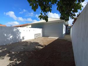 a white building next to a white fence at Casa Rua da Lagoa in Araruama