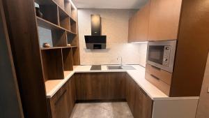 a small kitchen with a sink and a microwave at Svarog Unique Apartment by CHORS in Bratislava