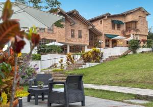 een huis met twee stoelen, een tafel en een parasol bij Valle de Santiago Hotel Boutique in San Cristóbal
