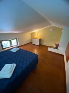 ein großes Schlafzimmer mit einem blauen Bett und Holzböden in der Unterkunft Appartamento Carnovale WiFi Piscina divertimento sul mare di Pizzo in Fondaco Vecchio