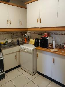 a kitchen with white cabinets and a counter top at Departamento Poniente a pasos del casino y playas in Viña del Mar +3 photos