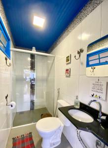 a bathroom with a toilet and a sink at Bangalô Charme Serra do Cipó in Santana do Riacho