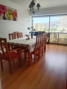 a dining room with a table and chairs and a large window at Departamento Poniente a pasos del casino y playas in Viña del Mar
