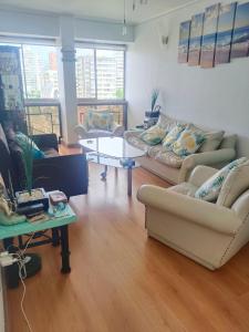 a living room with couches and a table at Departamento Poniente a pasos del casino y playas in Viña del Mar