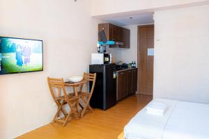 a small kitchen with a small table and a black refrigerator at Destiny Hotel - 1605 in Sampong +7 photos