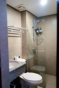 a bathroom with a toilet and a glass shower at Destiny Hotel - 1605 in Sampong
