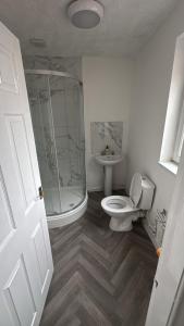 a bathroom with a shower and a toilet and a sink at Stadium Apart - Free Parking & WiFi in Crewe