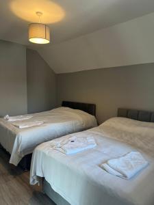two beds sitting next to each other in a room at Stadium Apart - Free Parking & WiFi in Crewe