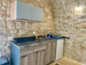 バトゥルーンにあるDomaine de Filiaの石壁のキッチン(シンク付)