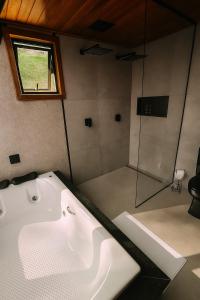 a bath tub in a bathroom with a window at Cabana Catuaí in Espera Feliz