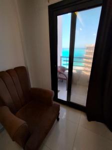 a living room with a chair and a view of the ocean at Luxury units for rent on the sea in Marsa Matruh