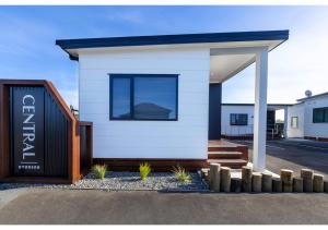 Una pequeña casa blanca con un cartel. en Central Studios, en Westport