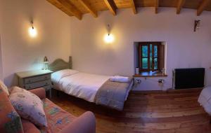 a bedroom with a bed and a couch and a window at The Walnut tree in San Miguel de Luena
