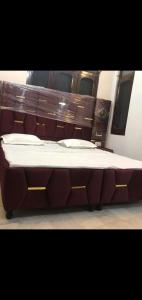 una cama grande con cabecero de madera en Hotel Gurujee residence, en Amritsar