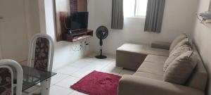 a living room with a couch and a tv at Condomínio Citta COP30 in Marituba