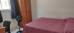 a bedroom with a bed and a fan next to a window at Condomínio Citta COP30 in Marituba