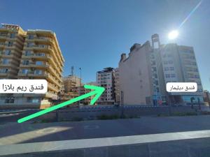 a view of a city with buildings with green arrows at Luxury units for rent on the sea in Marsa Matruh