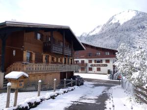 ein großes Holzgebäude mit Schnee auf dem Boden in der Unterkunft Chalet familial authentique et spacieux 2 chambres 4 à 6 personnes avec parking proche des remontées in La Chapelle-dʼAbondance