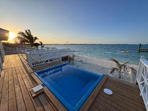 a hot tub on a deck next to the beach at The Calm Water Villas in Georgetown