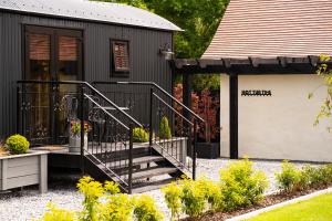 a black house with a staircase in front of it at Cherry Tree Lodge in Limavady
