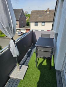 a patio with a table and a umbrella on a balcony at Wohlfuehloase24 in Gütersloh