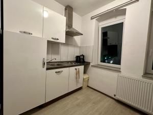 a white kitchen with a sink and a window at Fiddelhof in Bad Hersfeld +6 photos