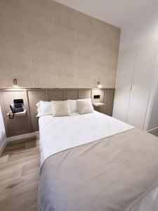 a bedroom with a large white bed with two pillows at Be RELAX TORREJON in Torrejón de Ardoz +14 photos