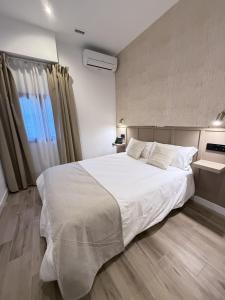 a bedroom with a large white bed and a window at Be RELAX TORREJON in Torrejón de Ardoz