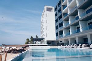 ein Schwimmbad vor einem Gebäude in der Unterkunft Avenir Armonia Suites in Rincón de Guayabitos