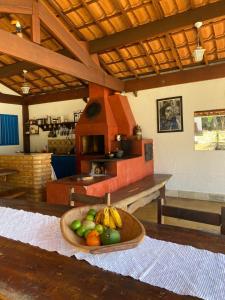 a bowl of fruit on a table in a kitchen at Bangalô Charme Serra do Cipó in Santana do Riacho