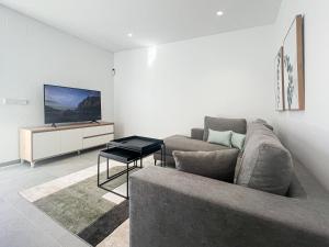 a living room with a couch and a tv at Casa del Rayo de Sol in San Pedro del Pinatar