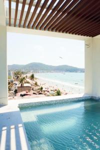 ein Swimmingpool mit Blick auf den Strand in der Unterkunft Avenir Armonia Suites in Rincón de Guayabitos