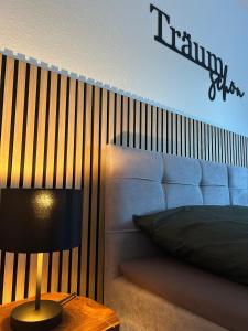 a bedroom with a bed and a table with a lamp at WälderNestchen - zentral - Natur pur - Tiefgarage - Balkon - modernes 2 Zimmer Appartement in Lenzkirch