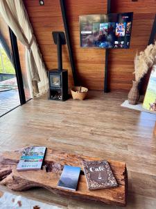 a room with a table with books and a stove at Cabana Catuaí in Espera Feliz