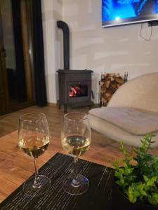 2 copas de vino blanco en una mesa con chimenea en Brvnara Relax, en Sekulić  12 fotos más