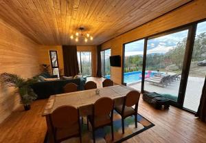 Una sala de estar con mesa y sillas y una piscina. en saguramo agaraki, en Saguramo