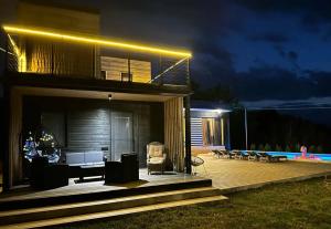 una casa con terraza de madera por la noche en saguramo agaraki, en Saguramo