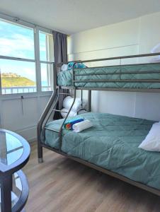 a bedroom with two bunk beds and a glass table at Marina Views & Island Adventures: Fajardo Condo with Pool in Beltran