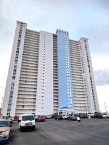 a large building with cars parked in a parking lot at Marina Views & Island Adventures: Fajardo Condo with Pool in Beltran