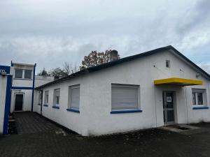 a white building with blue windows and a blue roof at TL Gastzimmer in Frankfurt/Main