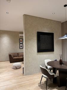 a living room with a table and chairs and a couch at Luxury 2BR - Steps To Boulevard in Riyadh