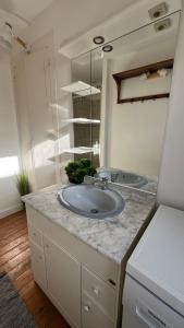 a bathroom with a sink and a mirror at La Vigie - Maison en bord de mer in Lion-sur-Mer +31 photos